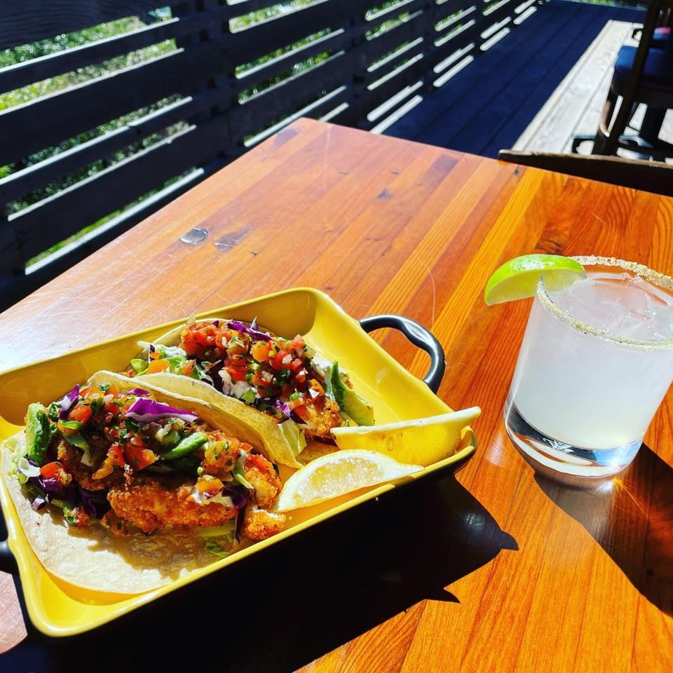 Moonstone Bar & Grill fish tacos with pico de gallo and a margarita on a sunny patio table.