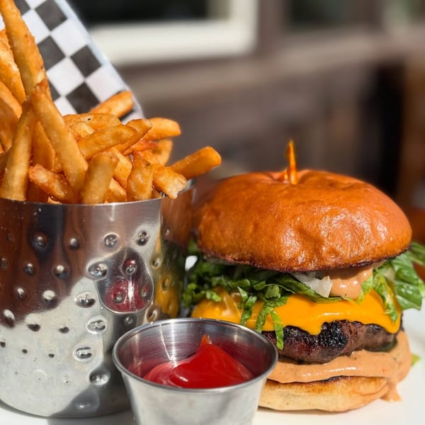 Moonstone Bar & Grill's cheeseburger with fries in a metal cup and a side of ketchup.